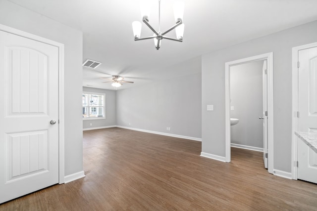 unfurnished living room with ceiling fan with notable chandelier and hardwood / wood-style floors