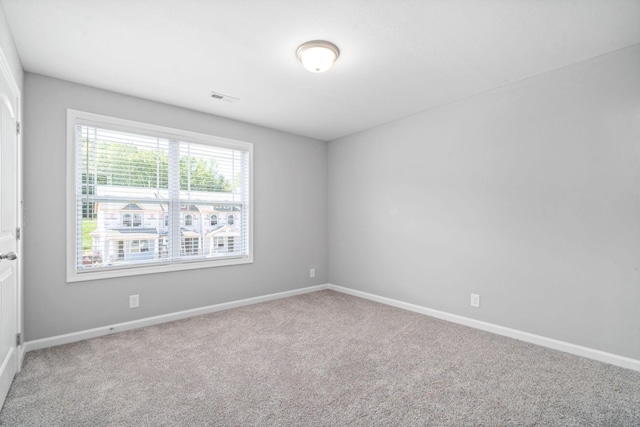 spare room with baseboards, visible vents, and carpet floors