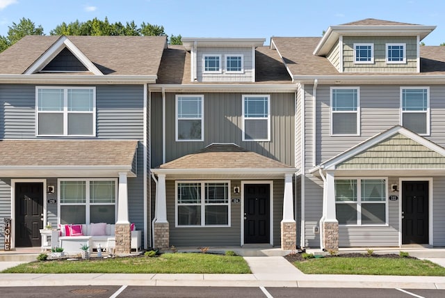 multi unit property featuring a porch, board and batten siding, and a shingled roof