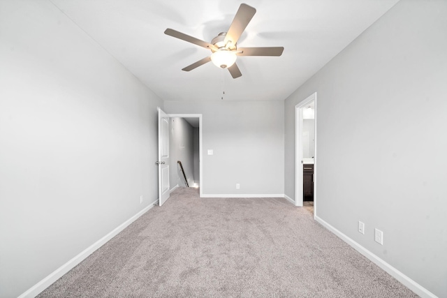 spare room with baseboards, light colored carpet, and ceiling fan