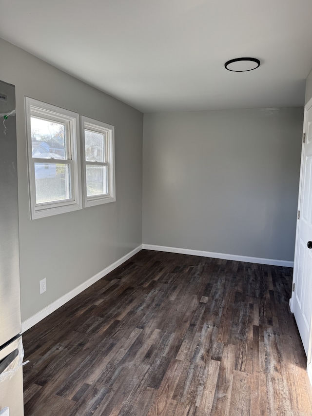 empty room with dark hardwood / wood-style flooring