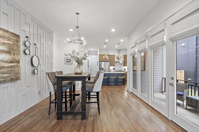 dining space with light wood-type flooring and a chandelier