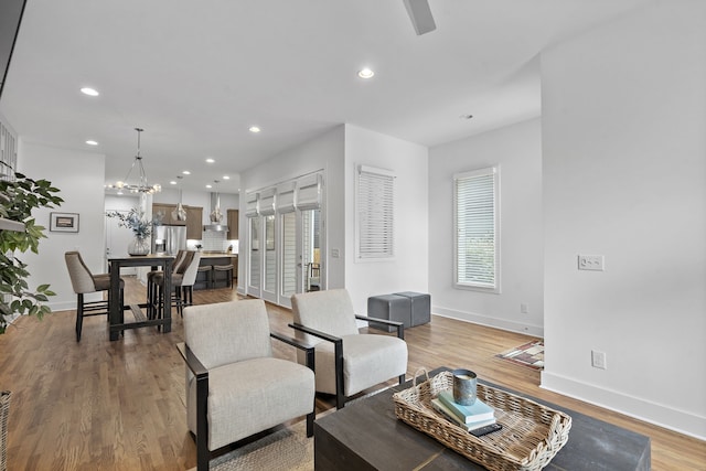 living room with hardwood / wood-style floors, a notable chandelier, and a healthy amount of sunlight