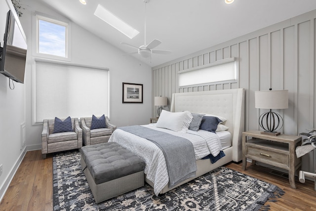 bedroom featuring dark hardwood / wood-style flooring, ceiling fan, and lofted ceiling with skylight