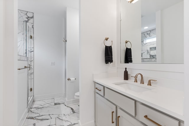 bathroom featuring vanity, toilet, and a shower with shower door