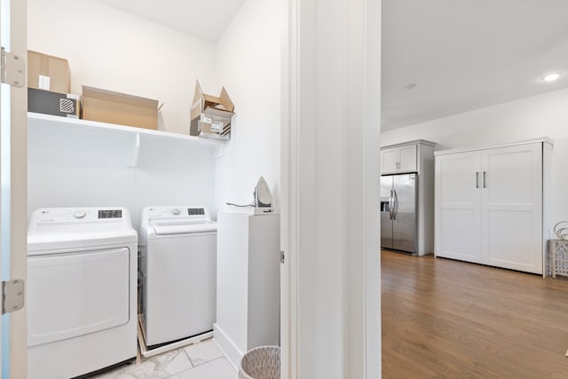 washroom with washer and clothes dryer and light wood-type flooring