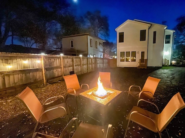 patio at night featuring a fire pit