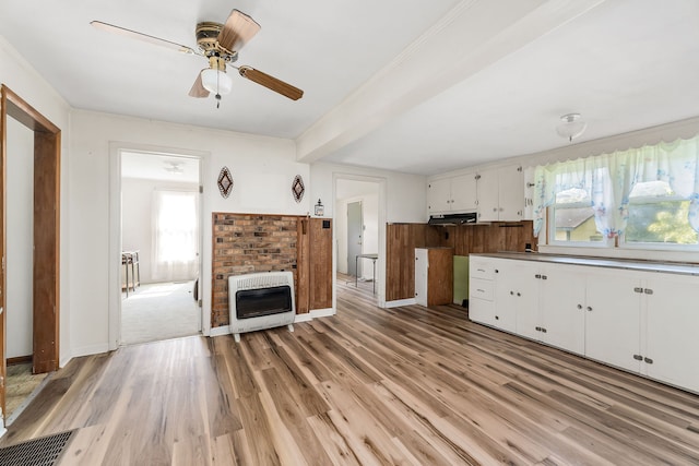 kitchen featuring ceiling fan, white cabinetry, heating unit, and a healthy amount of sunlight