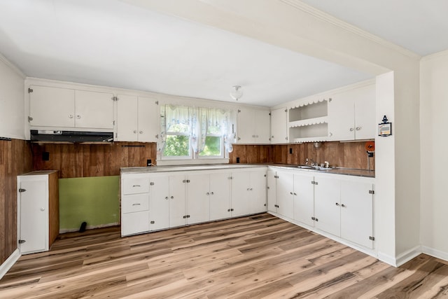 kitchen with crown molding, sink, wood-type flooring, and white cabinets