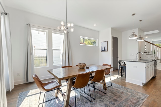 dining room featuring hardwood / wood-style flooring, sink, and a notable chandelier