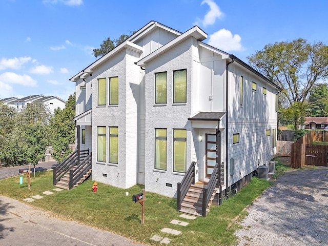 view of front of home featuring a front lawn and central AC