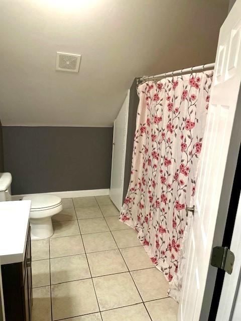 full bath with vanity, visible vents, toilet, lofted ceiling, and tile patterned floors