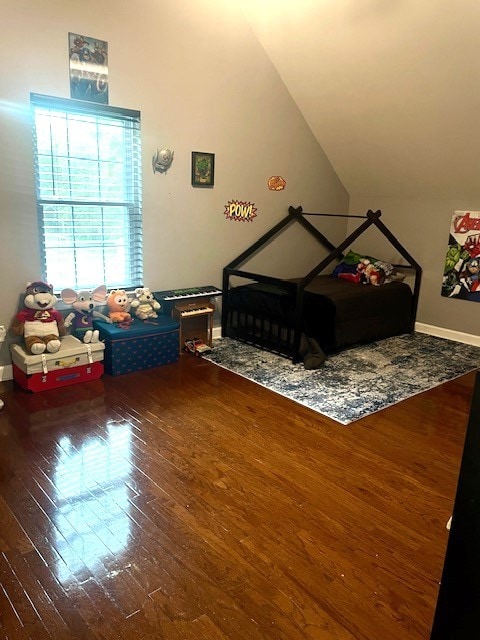 bedroom featuring lofted ceiling and hardwood / wood-style flooring