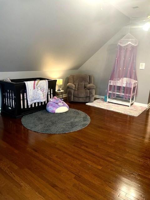 living area with baseboards, wood finished floors, and lofted ceiling