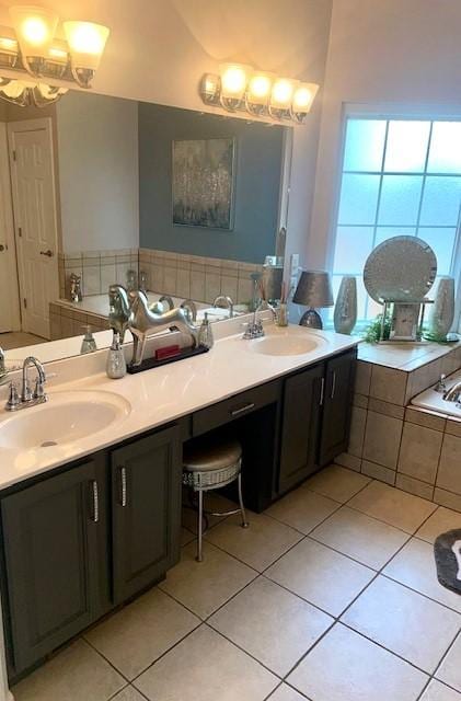 full bath with a sink, double vanity, an inviting chandelier, and tile patterned flooring