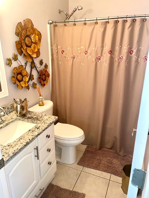 bathroom with a shower with shower curtain, tile patterned flooring, toilet, and vanity