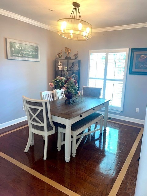 dining room featuring dark wood-type flooring, crown molding, and a notable chandelier