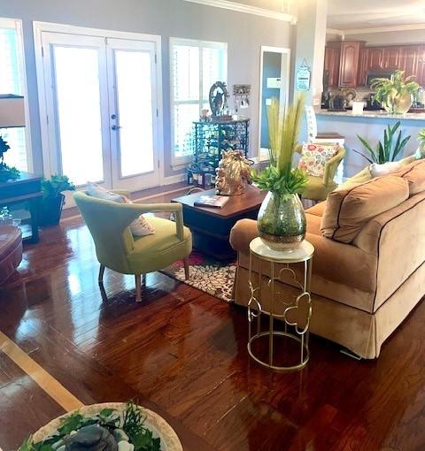 living area featuring french doors, hardwood / wood-style flooring, and crown molding