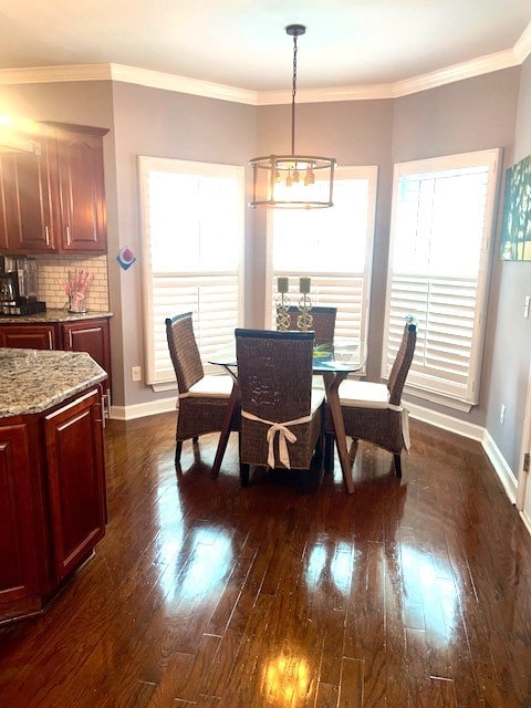 dining room featuring dark hardwood / wood-style flooring, ornamental molding, and a chandelier