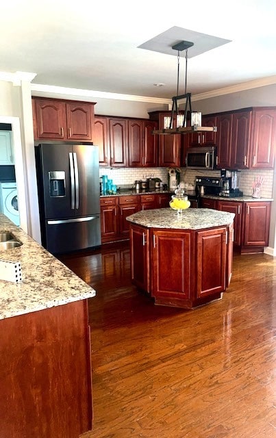 kitchen featuring appliances with stainless steel finishes, a center island, dark hardwood / wood-style floors, and ornamental molding