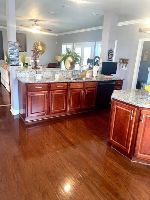 kitchen featuring dishwasher, a sink, ornamental molding, a ceiling fan, and light stone counters