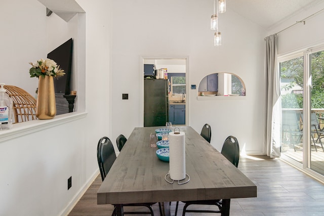 dining room with hardwood / wood-style flooring and vaulted ceiling