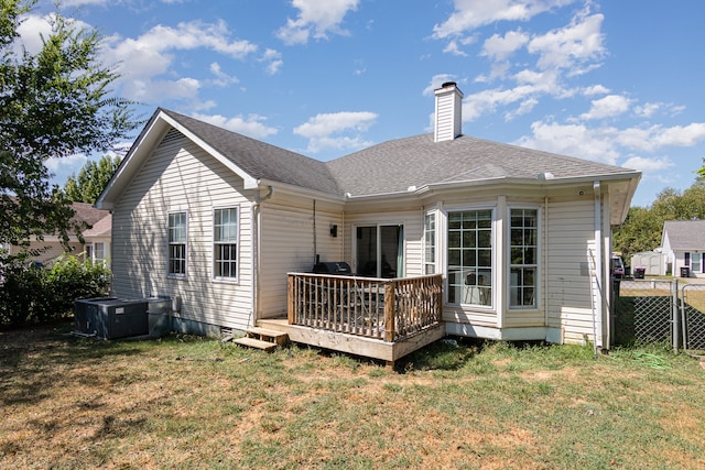 back of house featuring a lawn and a wooden deck