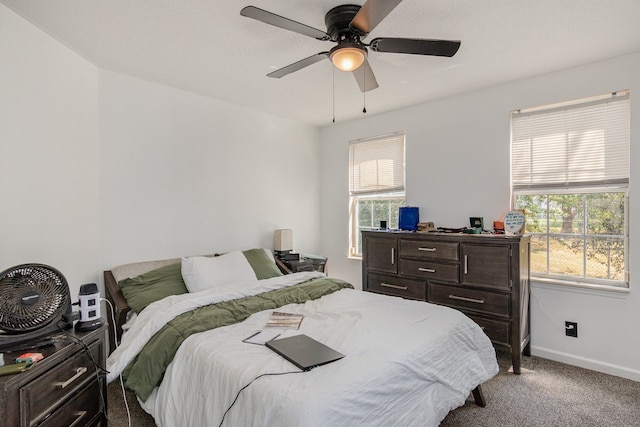 carpeted bedroom featuring multiple windows and ceiling fan