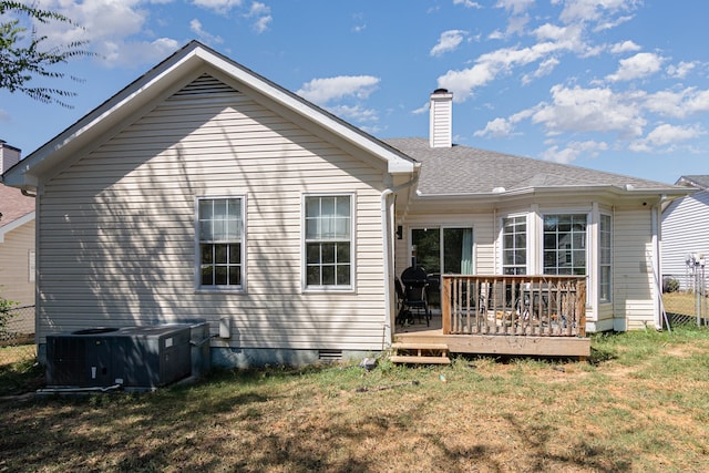 rear view of property with a yard, a deck, and central air condition unit