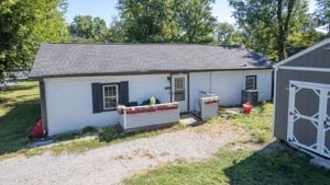 rear view of house featuring a storage unit