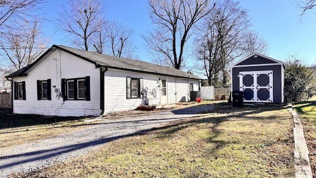 view of side of property with a yard and a storage unit