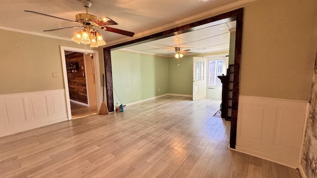 unfurnished room featuring ceiling fan, light wood-type flooring, and ornamental molding