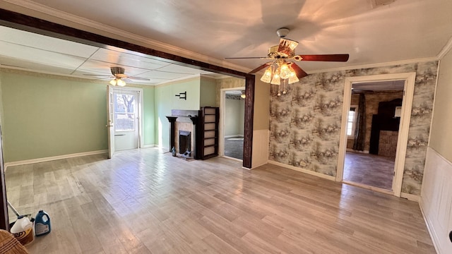 unfurnished living room featuring ceiling fan, wood-type flooring, and ornamental molding