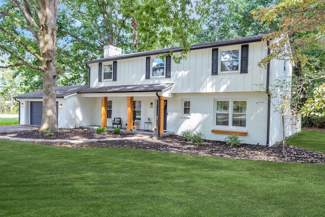 view of front of property featuring a garage, covered porch, and a front lawn