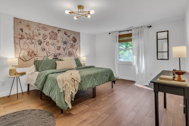 bedroom featuring hardwood / wood-style flooring and a chandelier