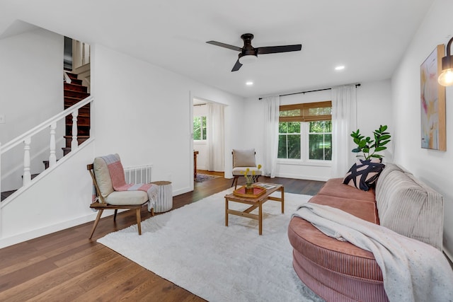 living room with dark wood-type flooring and ceiling fan