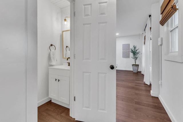 bathroom with vanity, wood finished floors, and baseboards