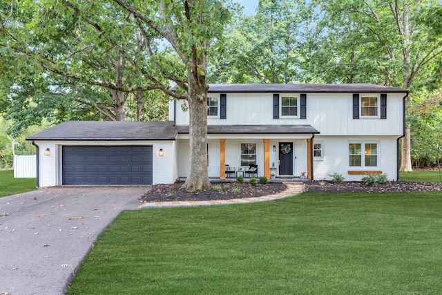 view of front of house with a porch, a garage, and a front lawn