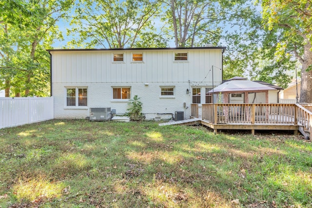 back of property featuring a yard, a deck, and central air condition unit