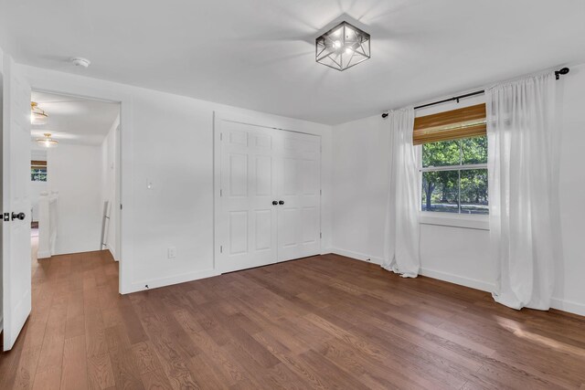 unfurnished bedroom with a closet and hardwood / wood-style flooring