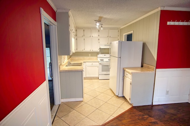 kitchen featuring ornamental molding, light tile patterned floors, white appliances, and white cabinets