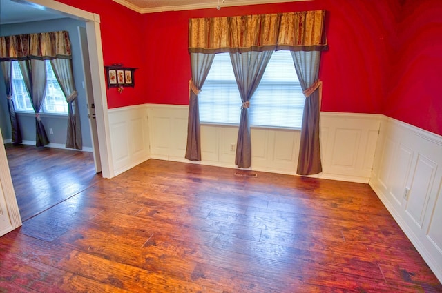 empty room with crown molding and dark wood-type flooring