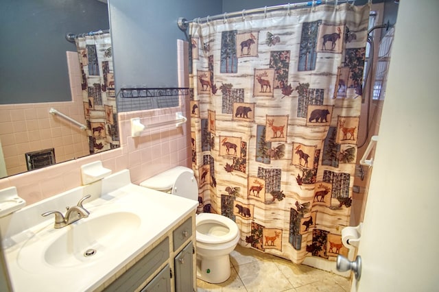 bathroom with toilet, tile patterned floors, vanity, tasteful backsplash, and tile walls