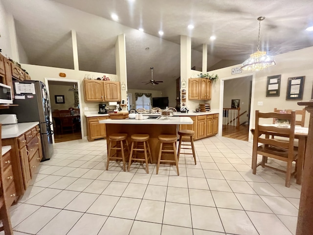 kitchen with kitchen peninsula, light tile patterned flooring, decorative light fixtures, and a breakfast bar area