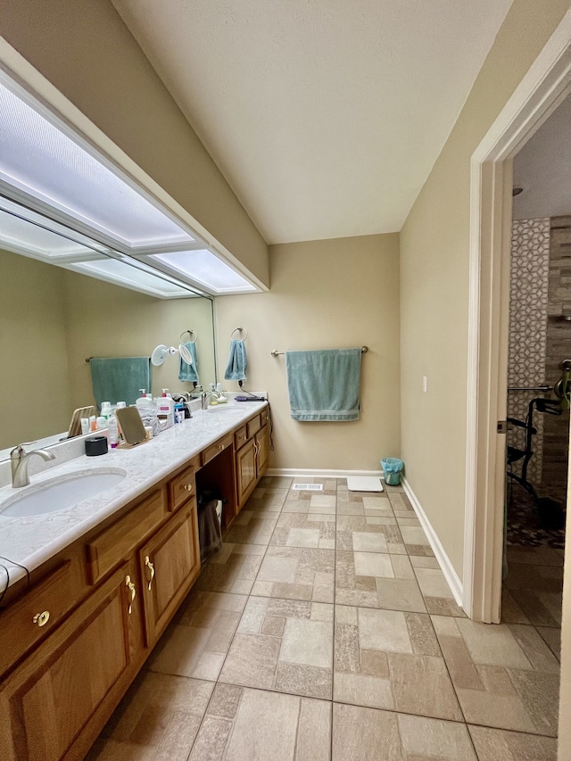 bathroom featuring tiled shower and vanity