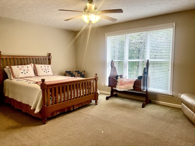 carpeted bedroom with a textured ceiling and ceiling fan