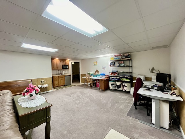 interior space featuring light colored carpet, a paneled ceiling, and sink