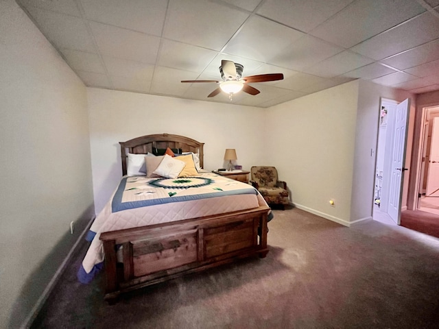 bedroom with ceiling fan, a drop ceiling, and carpet floors