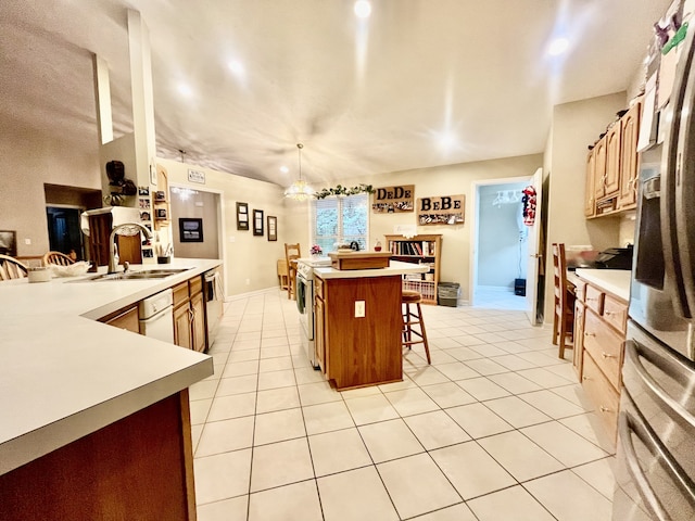 kitchen featuring appliances with stainless steel finishes, an island with sink, hanging light fixtures, a breakfast bar, and sink