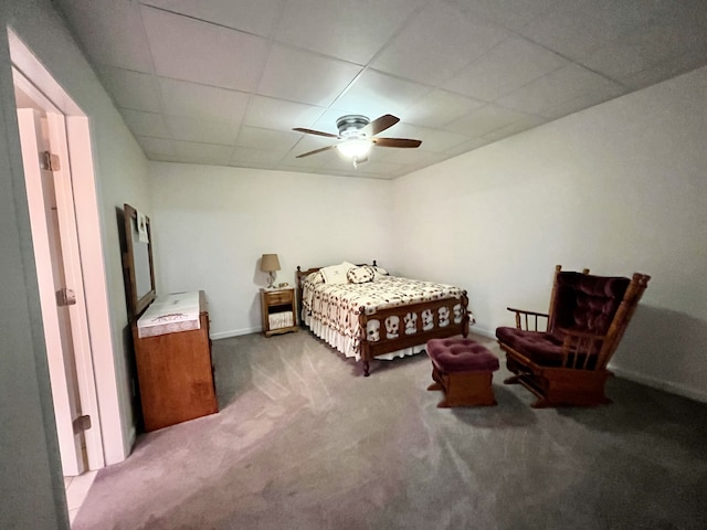 carpeted bedroom with ceiling fan and a drop ceiling